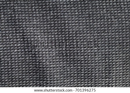 Texture of dark denim material photographed close-up. Small depth of field of jeans