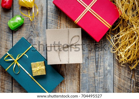 Colored gift boxes on brown wooden background with ribbons