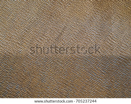 Old vintage knitted weaved grainy rough grey, brown, and gold thread fabric cloth background , with shade and shadow on the below half