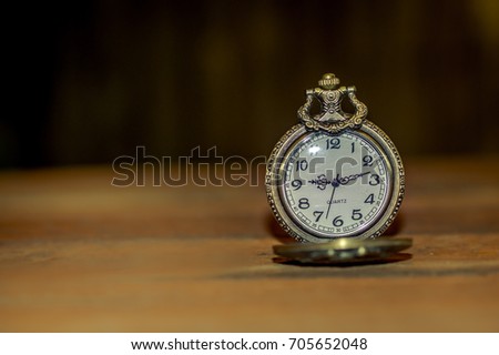 old vintage antique pocket clock showing time on the wooden board 