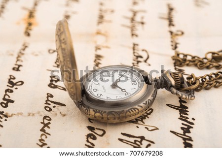 Vintage pocket watch over manuscript background