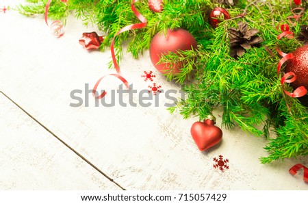 Christmas or New Year background: fur-tree branches, gifts, colored glass balls, decoration and cones on white wooden background
