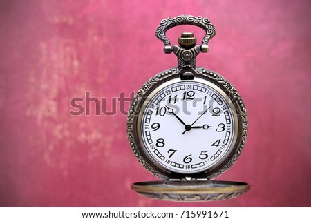 old pocket watch on grunge red wall background