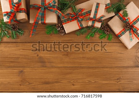 Creative presents in craft and grey paper decorated for any holiday concept. Gift boxes, fir tree branch, top view with copy space on rustic table background.