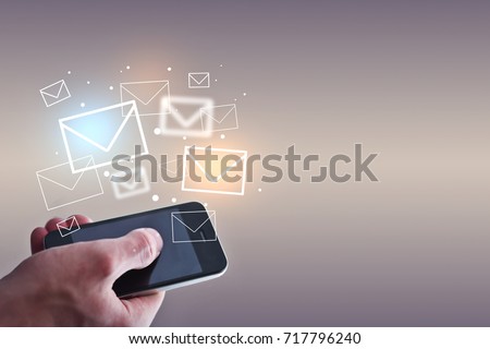 Businessman holding smartphone with emails on light background. Email marketing concept
