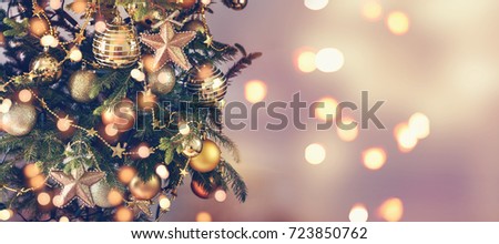 Gold Christmas background of de-focused lights with decorated tree
