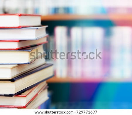 Blurred image, book stack on wood desk and bookshelf in the library room, business and education background, back to school concept