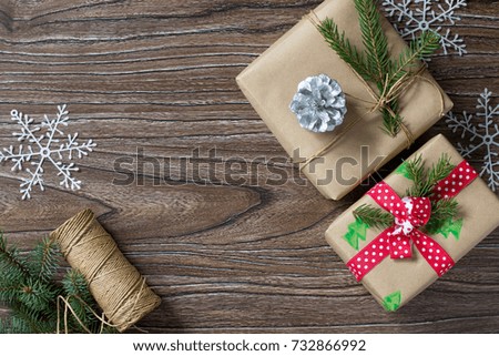 Christmas background with gift box. Christmas gifts in handmade boxes on a wooden table. Top view with copy space. Copy space.
