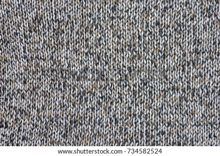 Close-up background of gray or brown sweater with abstract pattern