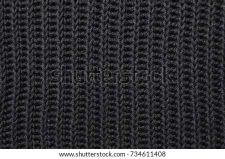 Texture of a black cotton sweater close-up. Top view. Textile clothing.