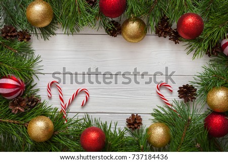 Template for Christmas card with fir tree border and copy space. Wooden table and natural pine branches.