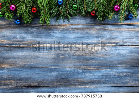 blue wooden background of old shabby boards and spruce branches with christmas toys. the concept of holidays