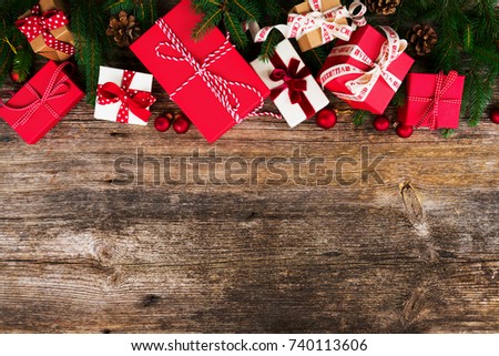 Christmas gift giving concept - christmas presents in red and white boxes on wooden table, flat lay with copy space