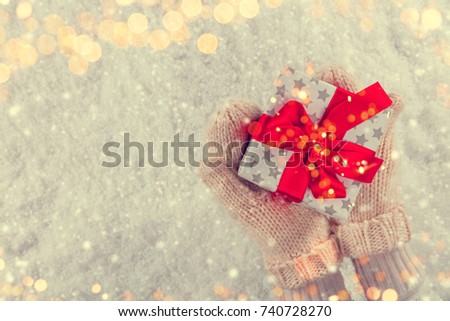 Woman hands holding Christmas gift, copyspace for text. Celebration and holidays concept. Colored in retro filter design. High resolution image