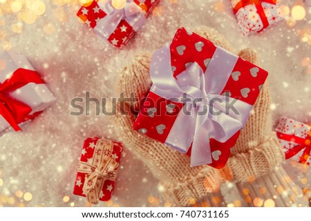 Woman hands holding Christmas gift. Celebration and holidays concept. Colored in retro filter design. High resolution image