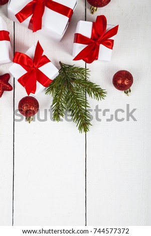 Gifts with red bows and Christmas decorations on a white wooden background. Congratulations on New Year or Christmas.
