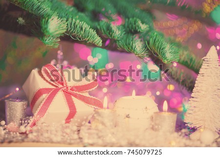 Christmas card. Background on a theme of New Year's  party. Decorated fir-tree with gifts and candles on the background of colorful festive lights. A magical evening.