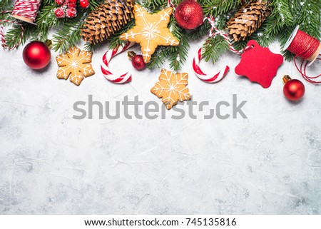 Christmas background. Christmas gingerbread, snow fir tree, red balls and decorations on gray stone background. Top view with copy space.