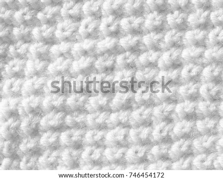 Knitted surface of white color is made by hand. Background of woolen threads.