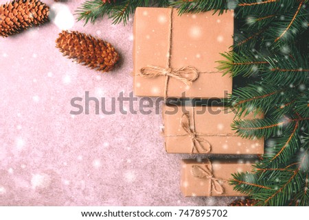 Christmas background. Craft gift boxes and decoration - Christmas tree branches and cones on slate marble background. Flat lay, copy space, top view.