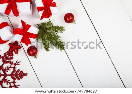 Christmas cookie with a red bow, spruce branch, gift and balls. Beautiful still life on a wooden table.