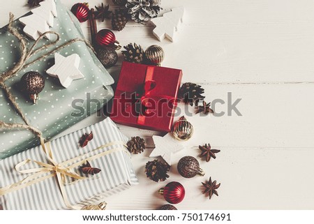 merry christmas concept, flat lay. presents with ornaments pine cones anise on rustic white wooden background top view, space for text. seasonal greetings card. happy holidays.