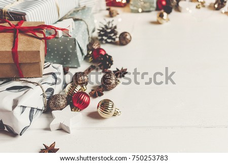 merry christmas concept. presents with ornaments pine cones anise and lights on rustic white wooden background top view, space for text. seasonal greetings card. happy holiday