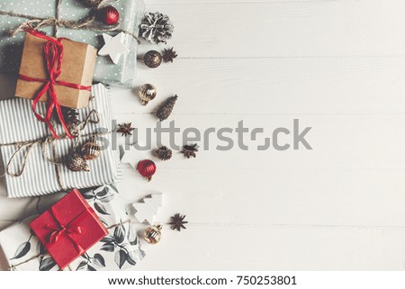merry christmas concept flat lay. presents with ornaments pine cones anise  on rustic white wooden background top view, space for text. seasonal greetings card. happy holidays