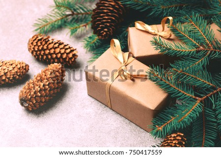 Christmas background. Craft gift boxes and decoration - Christmas tree branches and cones on slate marble background. Flat lay, copy space, horizontal view.