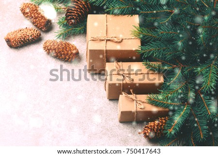 Christmas background. Craft gift boxes and decoration - Christmas tree branches and cones on slate marble background. Flat lay, copy space, top view.