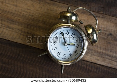 golden time clock - Golden bell clock on a wooden table background