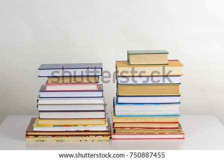 Piles of books in a flat style, on the table in studio against white background. Stack of books with bookmarks. Concept of learning.