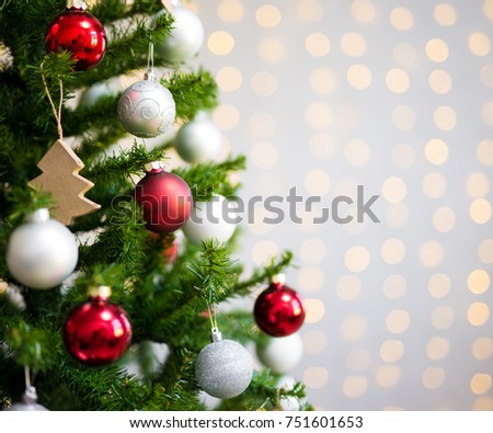 christmas background - close up of decorated christmas tree over white brick wall with shiny lights
