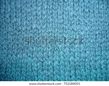 Texture of woolen jersey. Woolen fabric. Blue-green jersey.