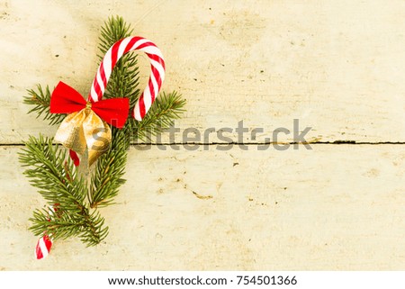 Christmas concept with sugar stick and fir branch on old wood board