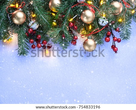 Christmas background decoration with lights, balls and fir tree flat lay on snow texture. Top view with blank space.