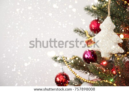 Close-up of Christmas tree with ornament, decoration and light bokeh with snowfall on winter background