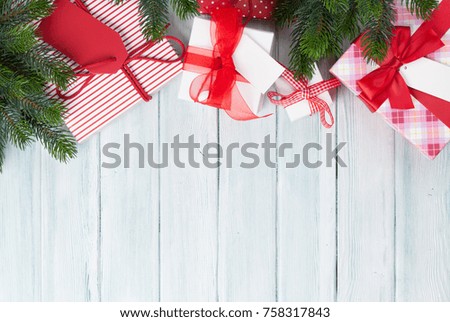 Christmas gift boxes and fir tree on wooden background. Top view with copy space