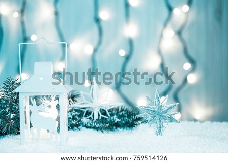Christmas candle lantern and Christmas tree branches, snow, snowflake and decorations on bokeh background blurred lights. Free space