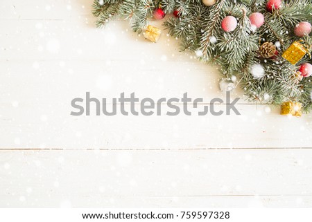 Fir branch with Christmas decorations on the white wooden table or plank background.