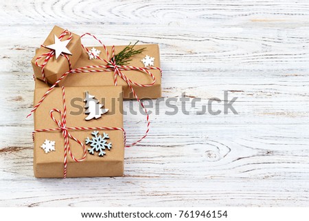 Three Festive Boxes in craf Paper Decorated with Snowflakes and star on Wooden Table. Top View.