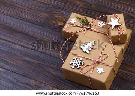 Christmas gift box decorated by snowflake on wooden background.