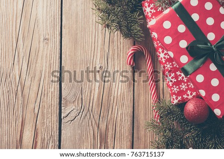 spruce branches and red boxes with gifts on a wooden background