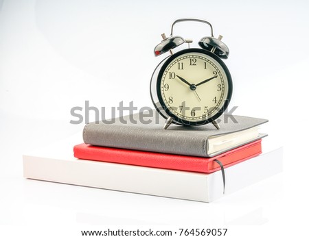 Clock and book with white background.