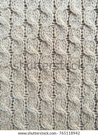 Closeup of beige knitted fabric texture background with beautiful pattern.