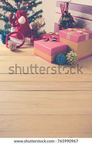 vintage tone image of Christmas ornaments with colorful light on pine tree and vary of decoration on wood table.