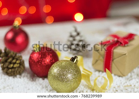 Christmas baubles on snow. With golden lights and the gift