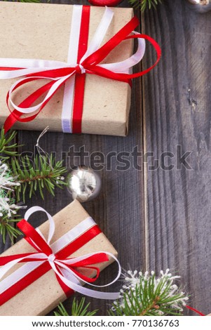 Christmas background with fir tree and decorations and gift boxes on wooden board.