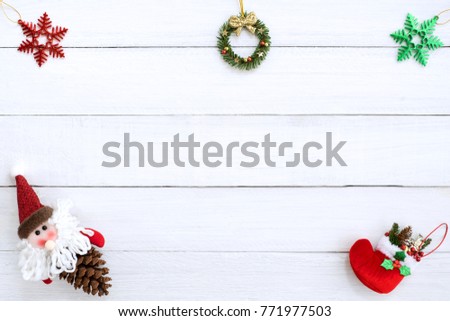 Christmas background. Christmas frame made of snow flake, christmas wreath, christmas red sock, and santa doll on pine cone, rustic elements on white wood board. Creative flat lay, top view design