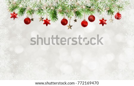 Christmas tree twigs, balls, garlands and snowflakes frame on holiday bokeh background